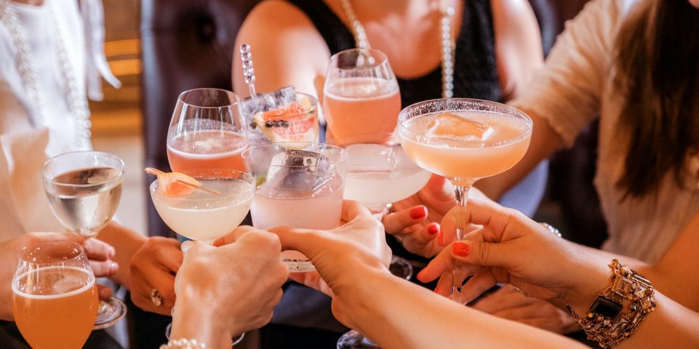 woman in black tank top holding clear wine glass