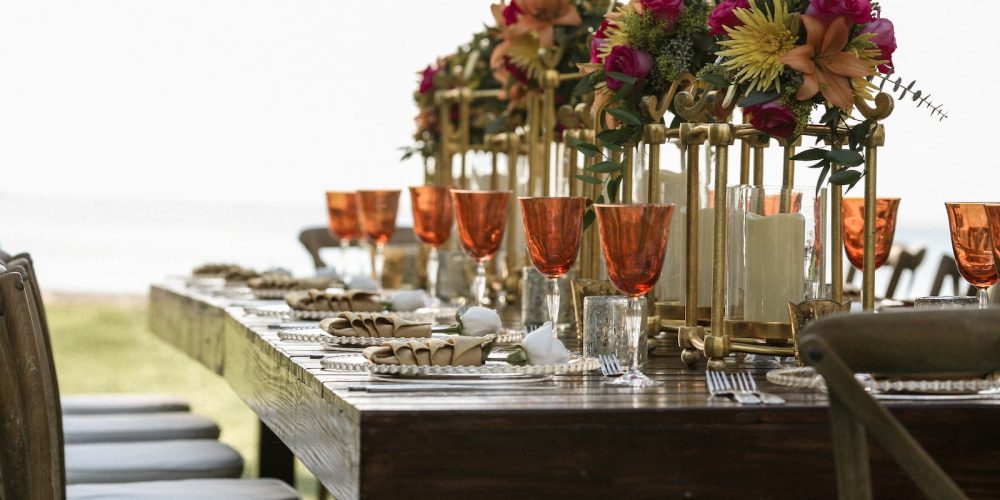 orange tinted wine glasses on rectangular brown wooden dining table