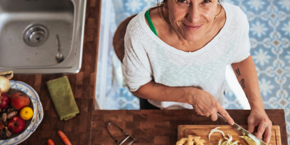 woman in white scoop neck shirt holding brown wooden chopping board