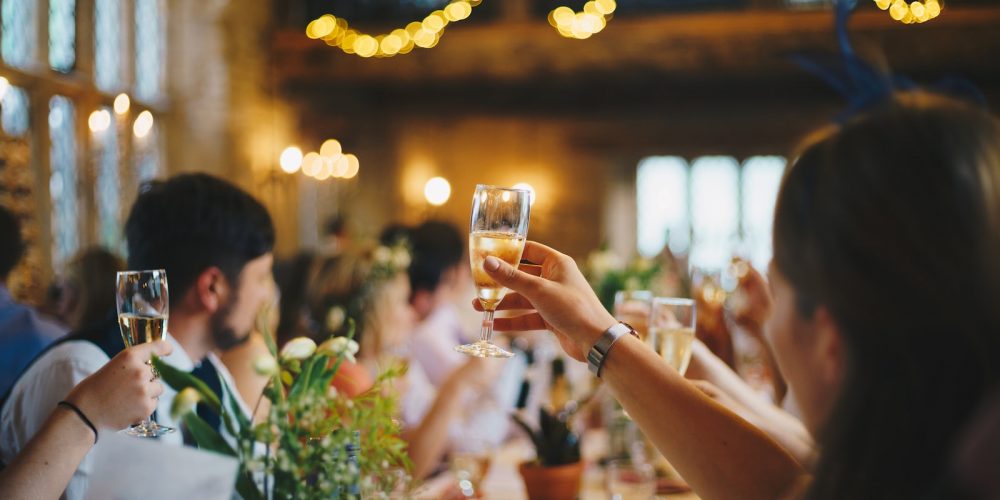 people raising wine glass in selective focus photography